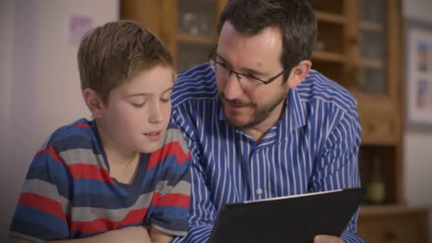 Padre e hijo usando una tableta de pantalla táctil — Vídeos de Stock