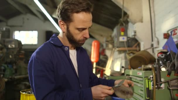 Mechanic repairing some part of an engine in an auto repair shop — Stock Video