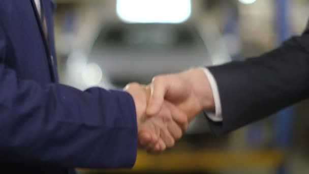 Close Up shot of mechanic and customer shaking hands in an auto repair shop — Stock Video