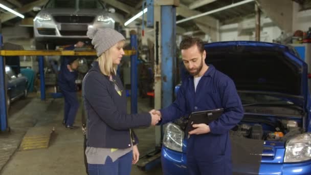 Mechanik vysvětlující výdaje na auto opravit jeho odběrateli — Stock video