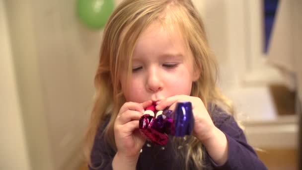 Ağır çekimde sevimli küçük kız parti üfleme boynuzları — Stok video