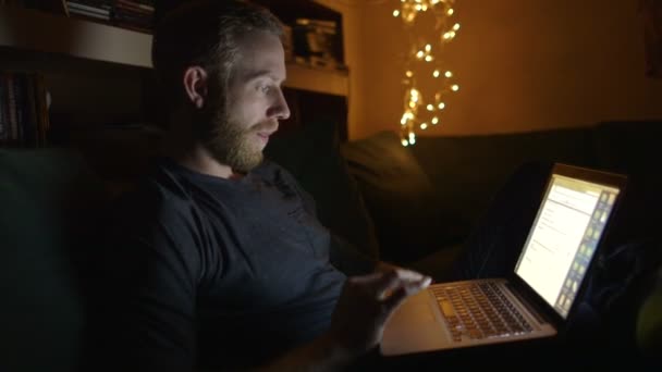 Heureux jeune homme d'affaires attrayant travaillant tard dans la nuit de la maison 