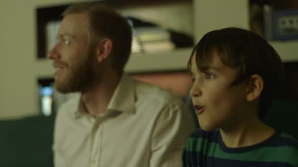 Vader speelt een video game met zoon na een lange dag op het werk — Stockvideo