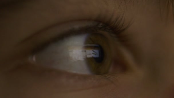 Gros plan des yeux d'une fille regardant un film sur une tablette 