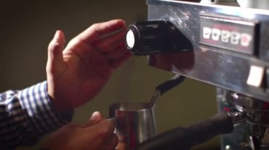 Barista latte vapur kullanarak süt köpüğü hazırlar