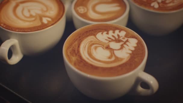 Cups served with intricate latte art — Stock Video