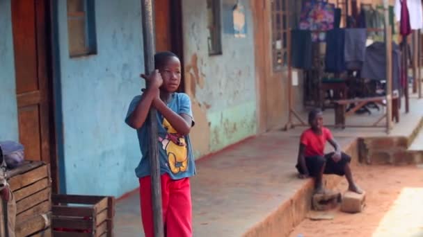 GAMBIA, 08 DE MARÇO DE 2012: Menino africano encostado ao correio no mercado local — Vídeo de Stock