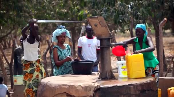 Gambia, 2012. március 08.: lány szivattyú vizet, a víz-állomás Afrikában. — Stock videók