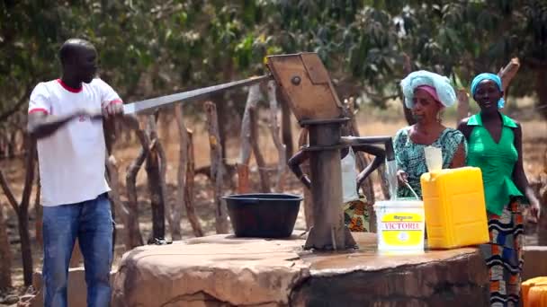 Gambie, 08 březen 2012: muž čerpadla vody z vodní stanice v Africe — Stock video