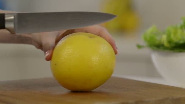 Vrouw Grapefruit snijden in de helft — Stockvideo