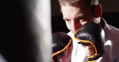 Genç bir atlet kum torbasına yumruk atma closeup.