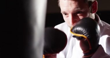 Tatlı bir genç sporcunun yavaş kum torbası ile boks.