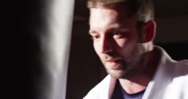 Genç bir atlet kum torbasına yumruk atma closeup.