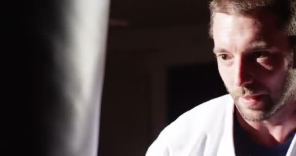 Closeup of a young athlete throwing punches at a punching bag. — Stock Video