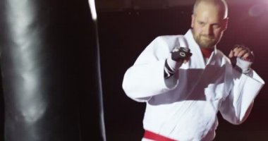 Kimono içinde genç bir atlet bir çanta yavaş hareket başladı.