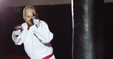 Kimono içinde genç bir atlet bir çanta yavaş hareket başladı.