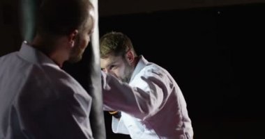 Eğitmen yavaş kum torbası ile pratik bir genç sporcu ile.