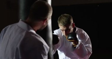 Eğitmen bir kum torbası ile pratik bir genç sporcu ile