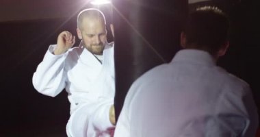 Eğitmen yavaş kum torbası ile pratik bir genç sporcu ile.