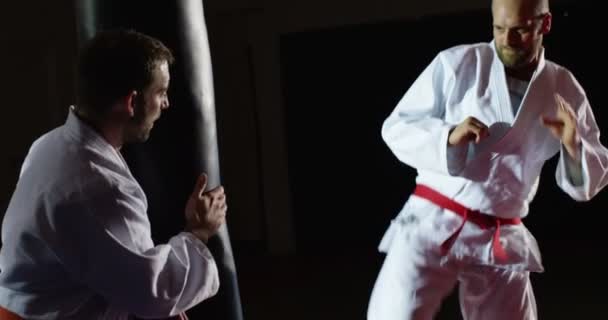 Entraîneur avec un jeune athlète pratiquant avec un sac de boxe . — Video