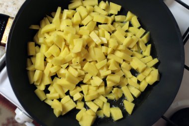  Yağda siyah bir tavada kızarmış patates.