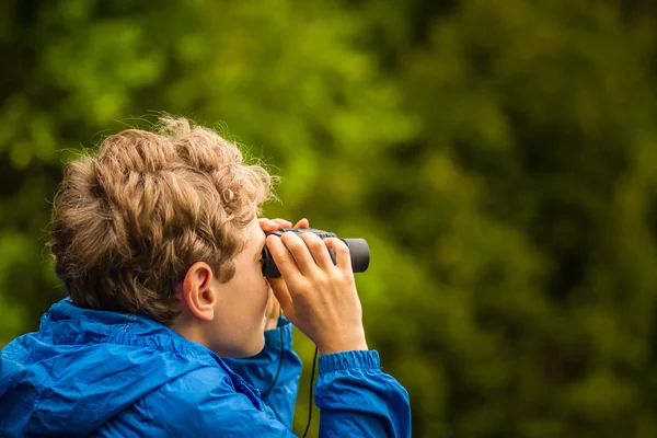 Мальчик наблюдает за птицей в лесу — стоковое фото
