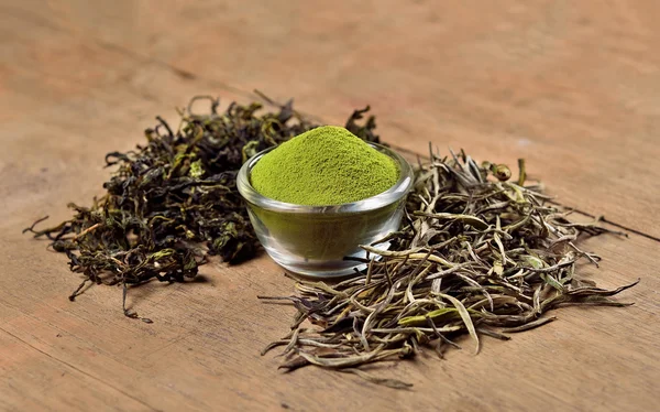 Torkade teblad och pulver på trä bakgrund — Stockfoto
