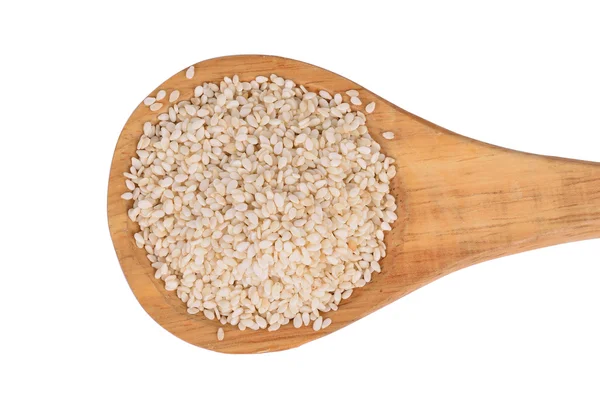 Sezamová semínka s dřevěnou lžící na bílém pozadí — Stock fotografie