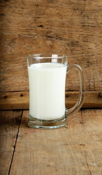 Sklo s mlékem na dřevěné pozadí — Stock fotografie