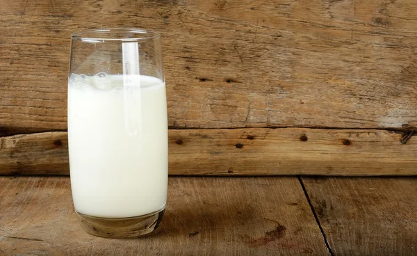 Sklo s mlékem na dřevěné pozadí — Stock fotografie