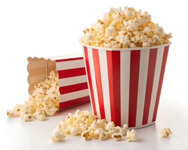 Büyük bir kova ve düşmüş bir kutu patlamış mısırın yakın plan çekimi. Beyaz arka planda kırmızı ve beyaz çizgili.