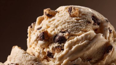 Çikolata parçalı kurabiye hamuru ve çikolata parçalarıyla dolu bir kepçe vanilyalı dondurmanın detaylı makro çekimi.
