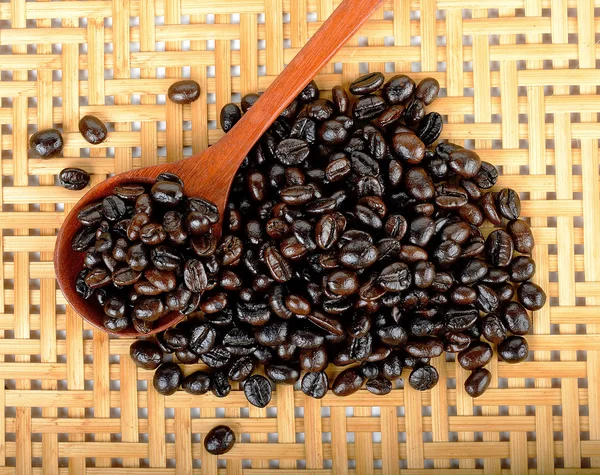 Kopi kacang dengan sendok kayu di latar belakang kayu — Stok Foto