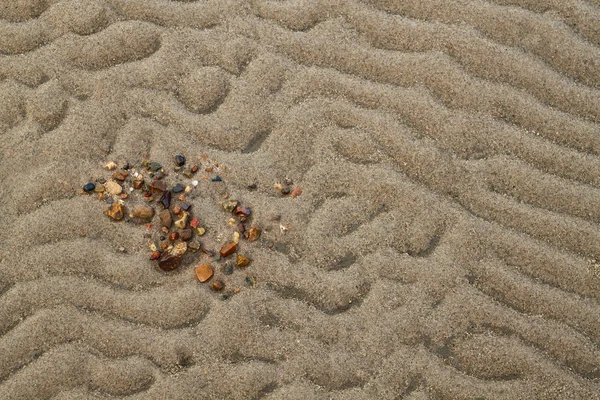 Wavy sandy texture with stones closeup — Stock Photo, Image