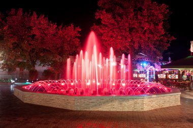 Bir çeşme ile gece kırmızı bir arka ışık