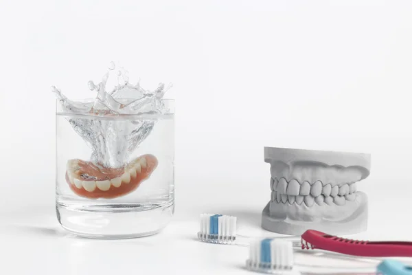 Concepto de higiene dental con vidrio y cepillo de dientes —  Fotos de Stock