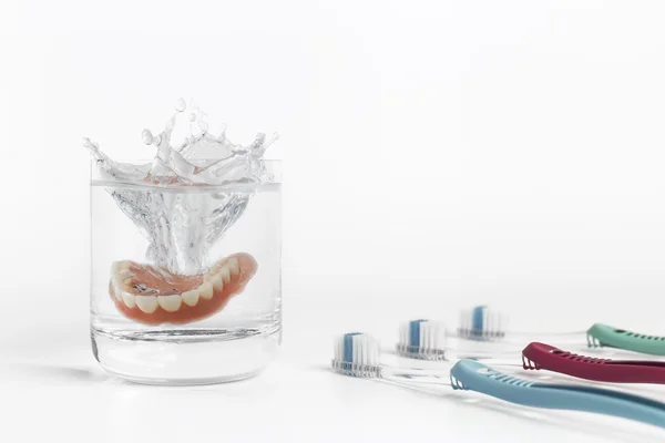 Concetto di protesi dentarie con vetro, maschera e spazzolino — Foto Stock
