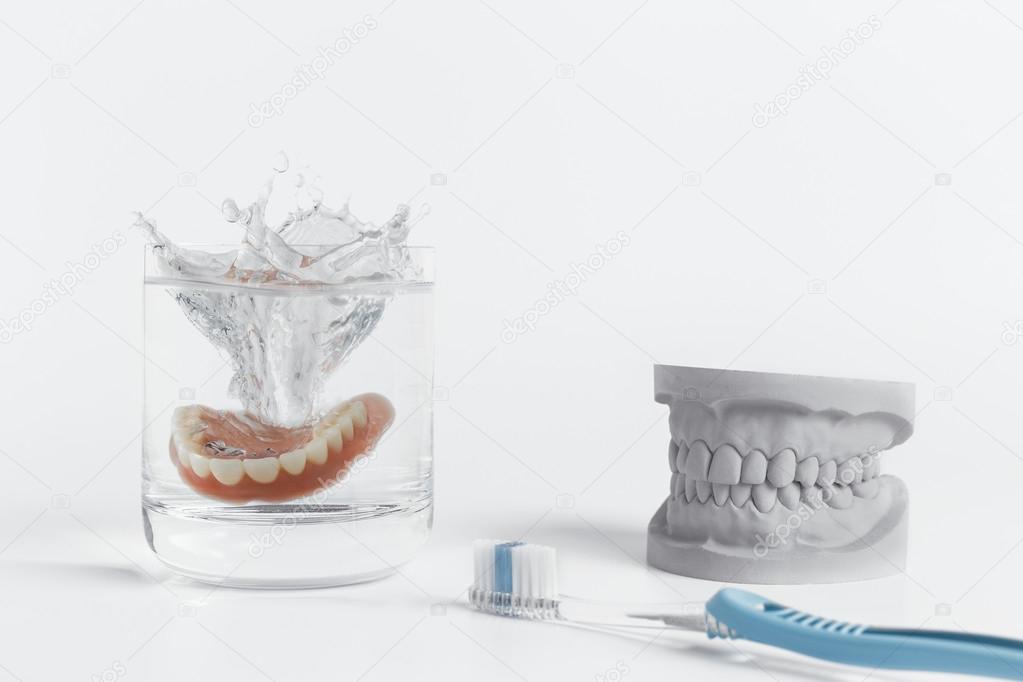 Denture hygiene concept with glass and toothbrush