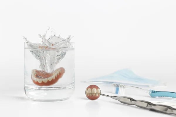 Diş Protez su yanındaki ayna üzerinde — Stok fotoğraf