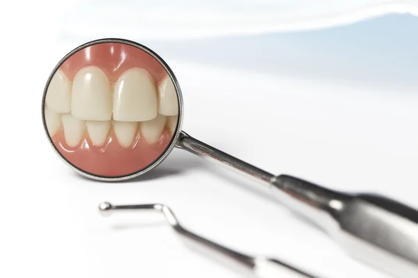 Dental spegelbild visar tänder bredvid pick — Stockfoto