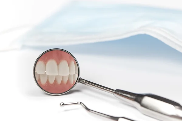 Zahnspiegel zeigt Bild der Zähne neben Spitzhacke — Stockfoto