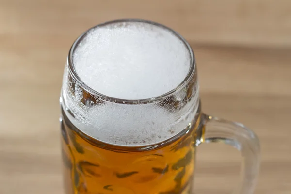 Beer with a frothy head in a glass beer mug — Stock Photo, Image