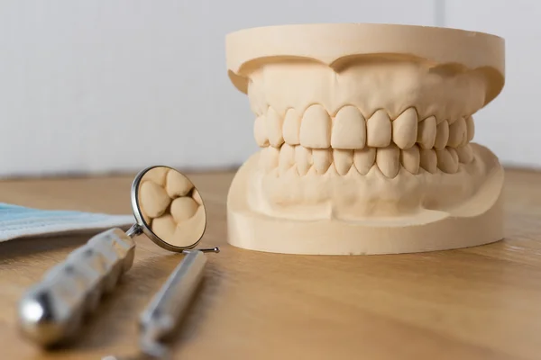 Molde dental con herramientas y mascarilla facial —  Fotos de Stock