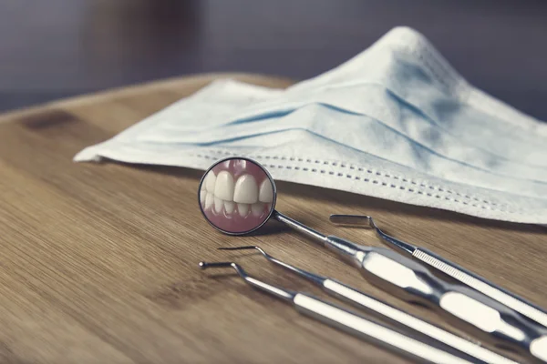 Strumenti dentisti e maschera con riflesso dei denti — Foto Stock