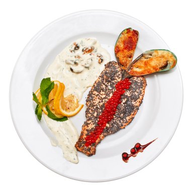 Üstten Görünüm limon ve kremalı mantar sos ile haşhaş tohumu kızarmış kırmızı balık. Kızarmış midye peynir ve kırmızı havyar ile.