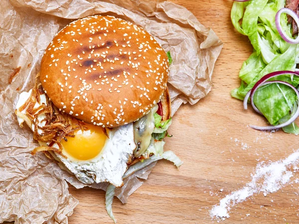 Бургер с яйцом, луком и листьями салата — стоковое фото