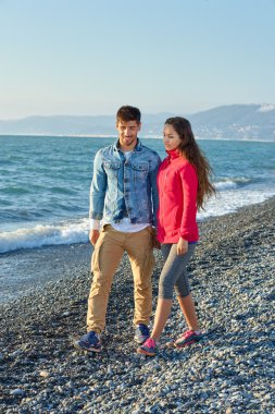 Sahilde yürüyüş ve birbirleriyle konuşmak genç Çift.
