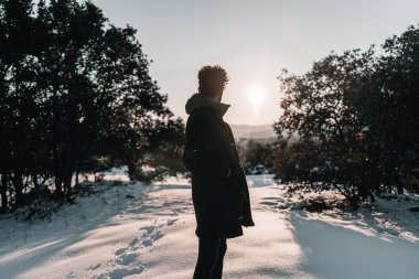 Gün batımında dağda bir adamın silueti.