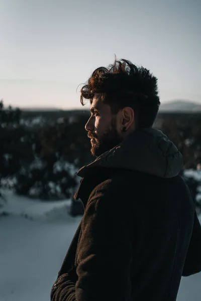 Portrait of a man on the mountain in the snow at sunset