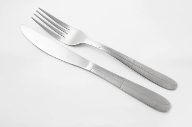 Beyaz arka planda paslanmaz çelik çatal bıçak takımı var. çatal ve bıçak.